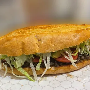 a sandwich with lettuce and tomatoes