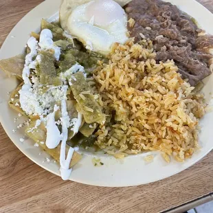 Chilaquiles verdes with over easy egg and rice and beans