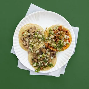 three tacos on a paper plate