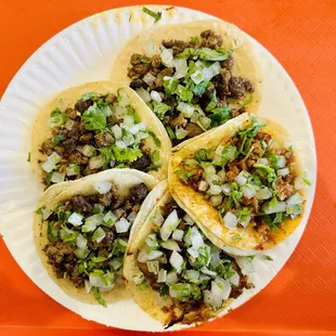four tacos on a paper plate