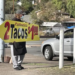 a man holding a taco&apos;bout sign