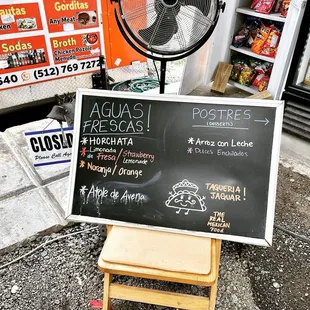 a table with a fan and a sign