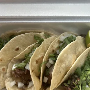 three tacos in a styrofoam container