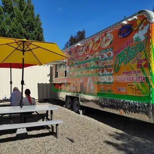  a taqueria jalisco express truck parked next to a picnic table with an