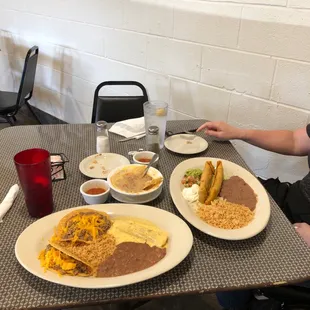 a woman sitting at a table with plates of food