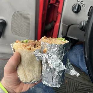 a hand holding a burrito