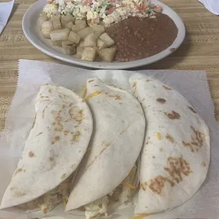 a plate of quesadillas and a plate of potato salad