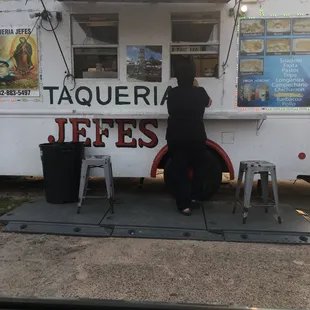 a woman standing in front of a food truck