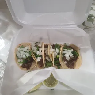 three tacos in a styrofoam container
