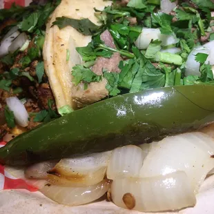 a close up of a taco with onions and a pickle