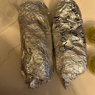 two burritos wrapped in foil