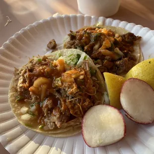 a plate of tacos and sliced radishes
