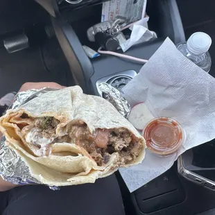 Inside is Beans, rice, meat, cilantro, sour cream and onion.