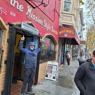 a man standing in the doorway of a restaurant