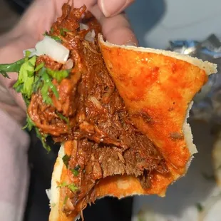 a hand holding a sandwich