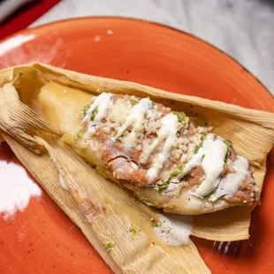 a fish enchilla wrapped in a banana leaf