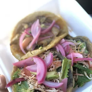 two tacos in a styrofoam container