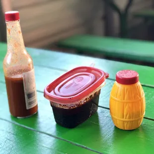 a hot sauce and a bottle of ketchup