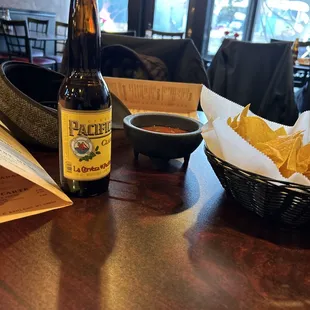 a bottle of beer and a basket of chips