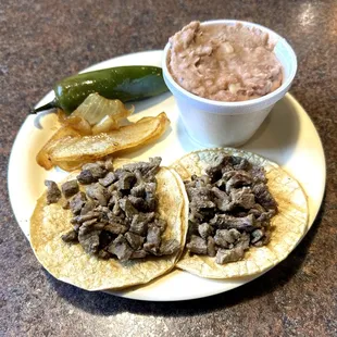 Two Asada (Steak) Tacos with a Small Side of Beans Before a Trip to the Toppings and Salsas Bars