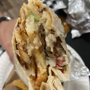 a hand holding a burrito