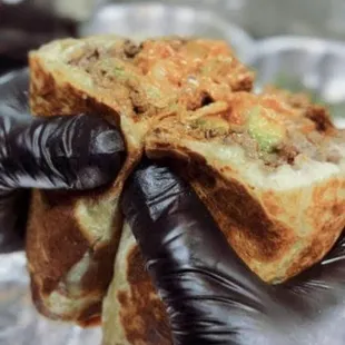 a hand holding a piece of bread