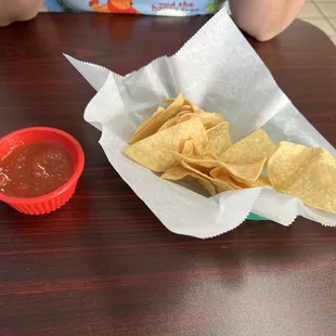 a basket of tortillas and a bowl of salsa
