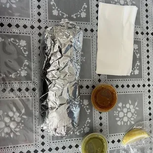 a hot dog wrapped in aluminum foil