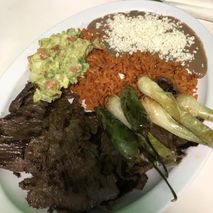 Azada/Steak platter with quac, rice, beans, and some chili/green onion for garnish I think lol.