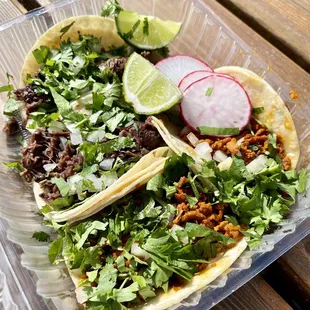 two tacos in a plastic container