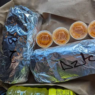 a taqueria burrito, a burrito, and a bag of chips