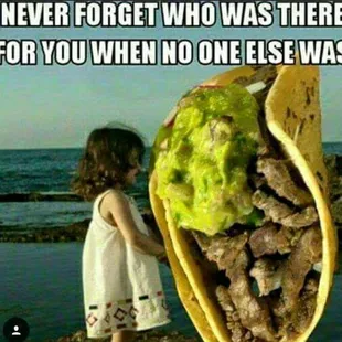 a little girl looking at a taco