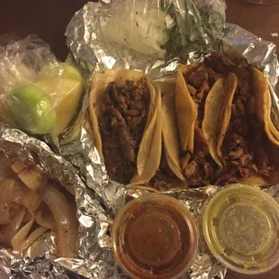 Grilled onions, cucumber, lemon, onion, cilantro, salsa, &amp; Asada + Pastor tacos.