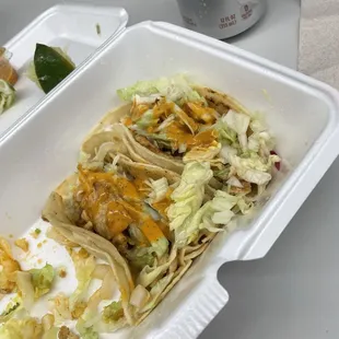 Chicken Taco with lettuce and hot sauce.