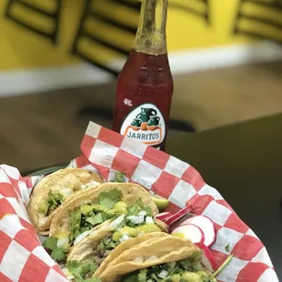 a plate of tacos and a bottle of soda