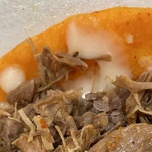 a close up of a taqueria with meat and cheese