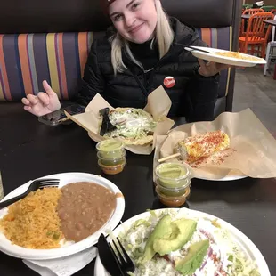 a woman sitting at a table with plates of food