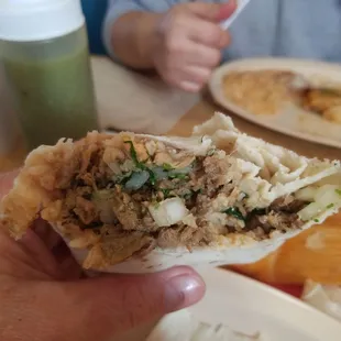 a hand holding a burrito