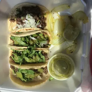 Tacos asadas and barbacoa with salsa verde and grilled onions