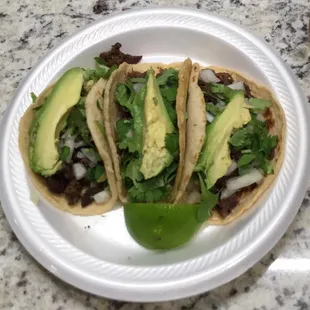 three tacos on a paper plate
