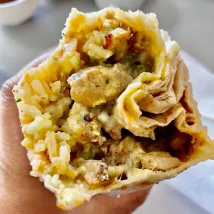 a hand holding a burrito
