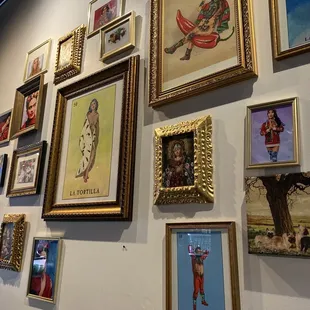 a wall of framed art