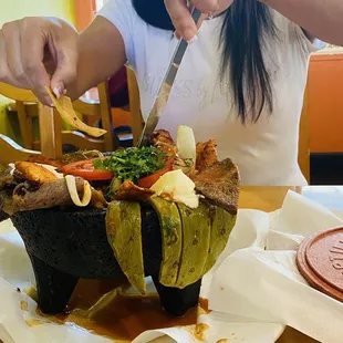 a woman cutting a piece of food