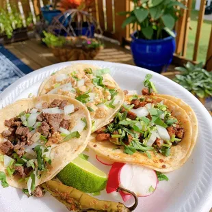 three tacos on a paper plate