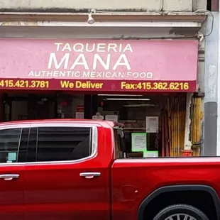a red truck parked in front of a restaurant