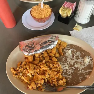 Huevos revueltos (scrambled eggs with Chorizo, friend potatoes, refried beans) with a side of rice.