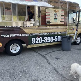 a dog standing in front of a food truck