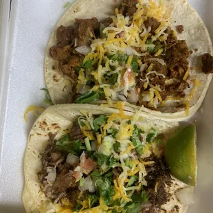 two tacos in a styrofoam container