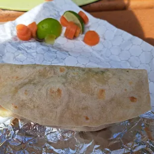 $12 carne asada super burrito with carrots and lime