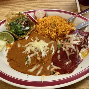 This is a chicken enchilada and carnitas street taco served with beans and rice.